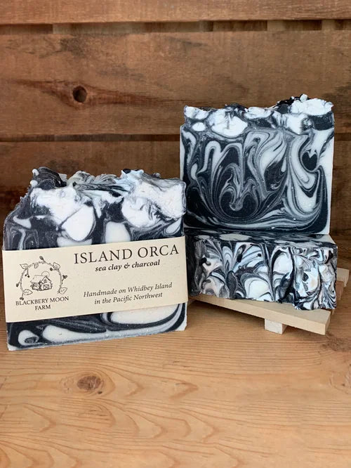 Island Orca handmade soap bars with black and white swirl design displayed on a wooden stand
