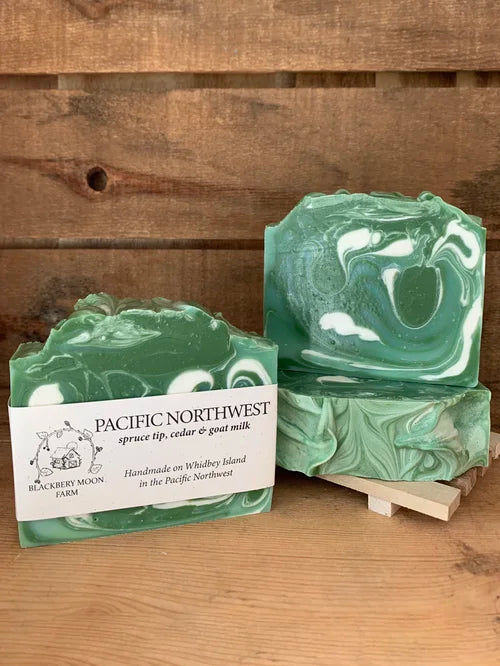 Pacific Northwest handmade soap bars with green and white swirl design displayed on a wooden stand 
