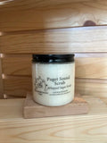 Puget Sound whipped sugar scrub in clear jar with black lid on wooden blocks 