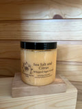 Sea Salt and Citrus whipped sugar scrub in clear jar with black lid on wooden blocks 