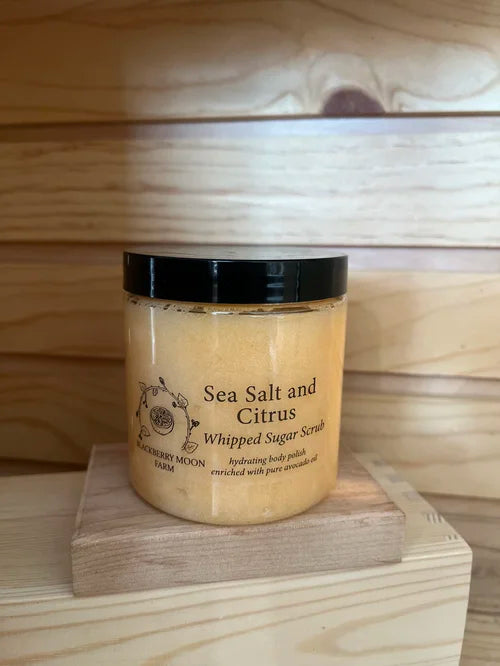 Sea Salt and Citrus whipped sugar scrub in clear jar with black lid on wooden blocks 
