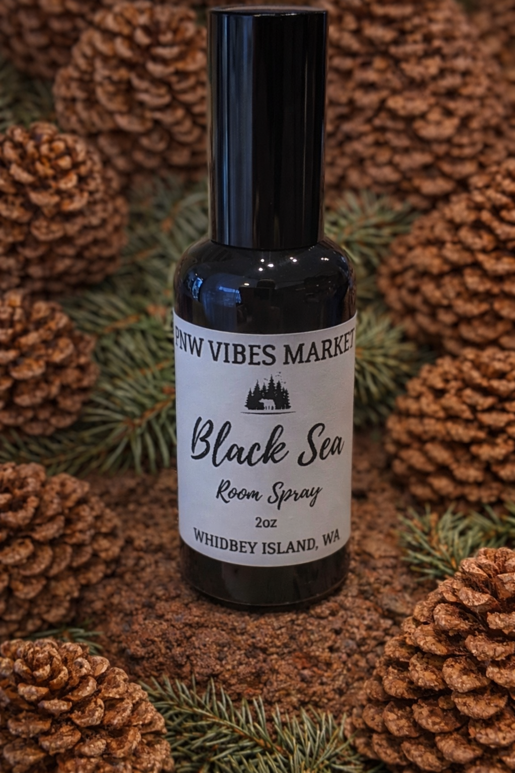 Black Sea room spray in dark bottle with black spray top on pinecone background