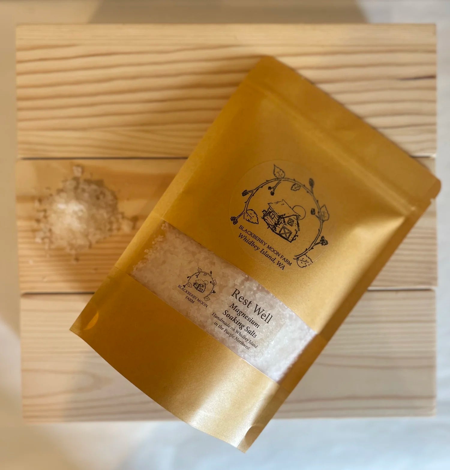 Rest Well magnesium soaking salts in a brown resealable pouch with a clear window showing bath salts