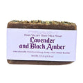Lavender and black amber goat milk soap bar with label on white backround
