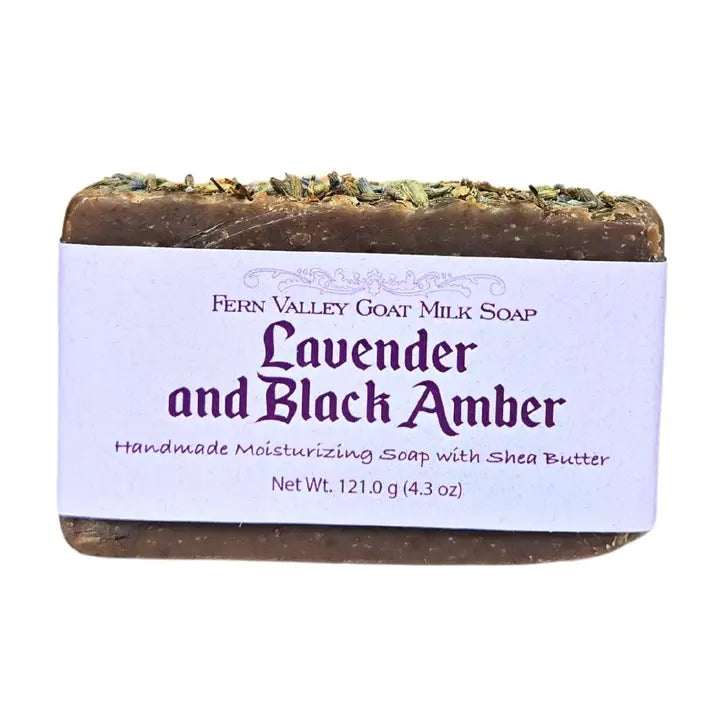 Lavender and black amber goat milk soap bar with label on white backround