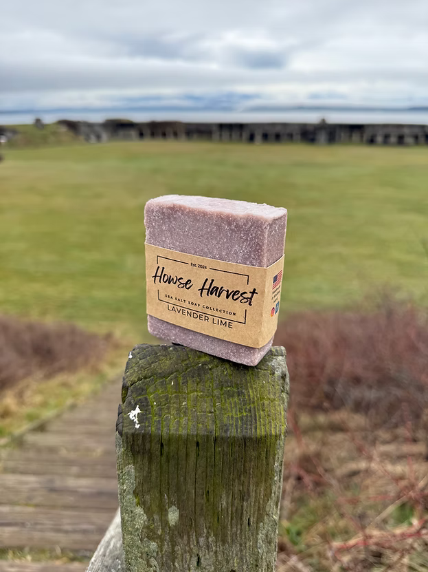 Handmade lavender lime soap bar on rustic wooden post outdoors