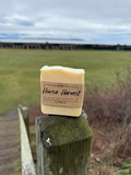 Handmade citrus soap bar on rustic wooden post outdoors