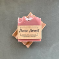 Handmade coconut rose soap bar with label on dark background