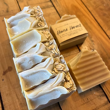 Handmade oatmeal bar soaps on wooden surface with soap box