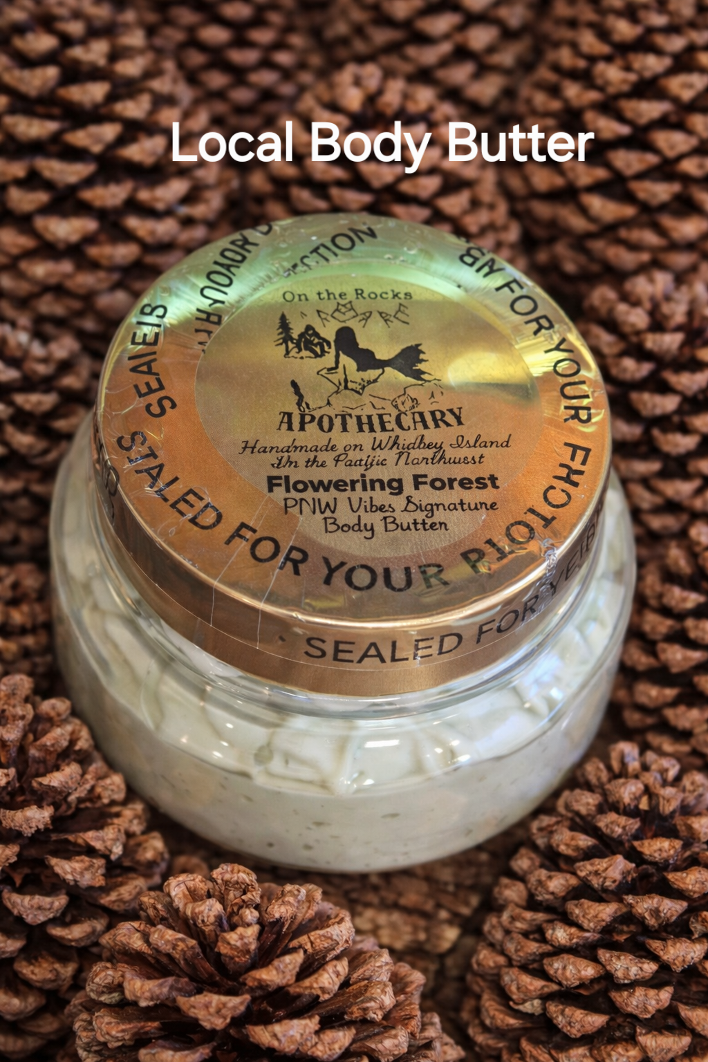 Jar of On the Rocks Apothecary Flowering Forest body butter with gold lid on pinecone background