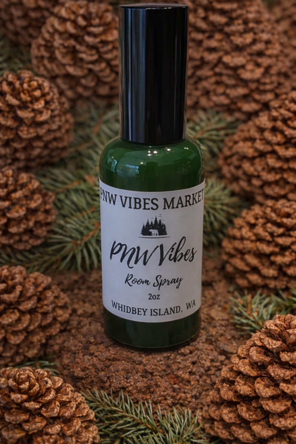 PNW Vibes room spray in green bottle on pinecone background.