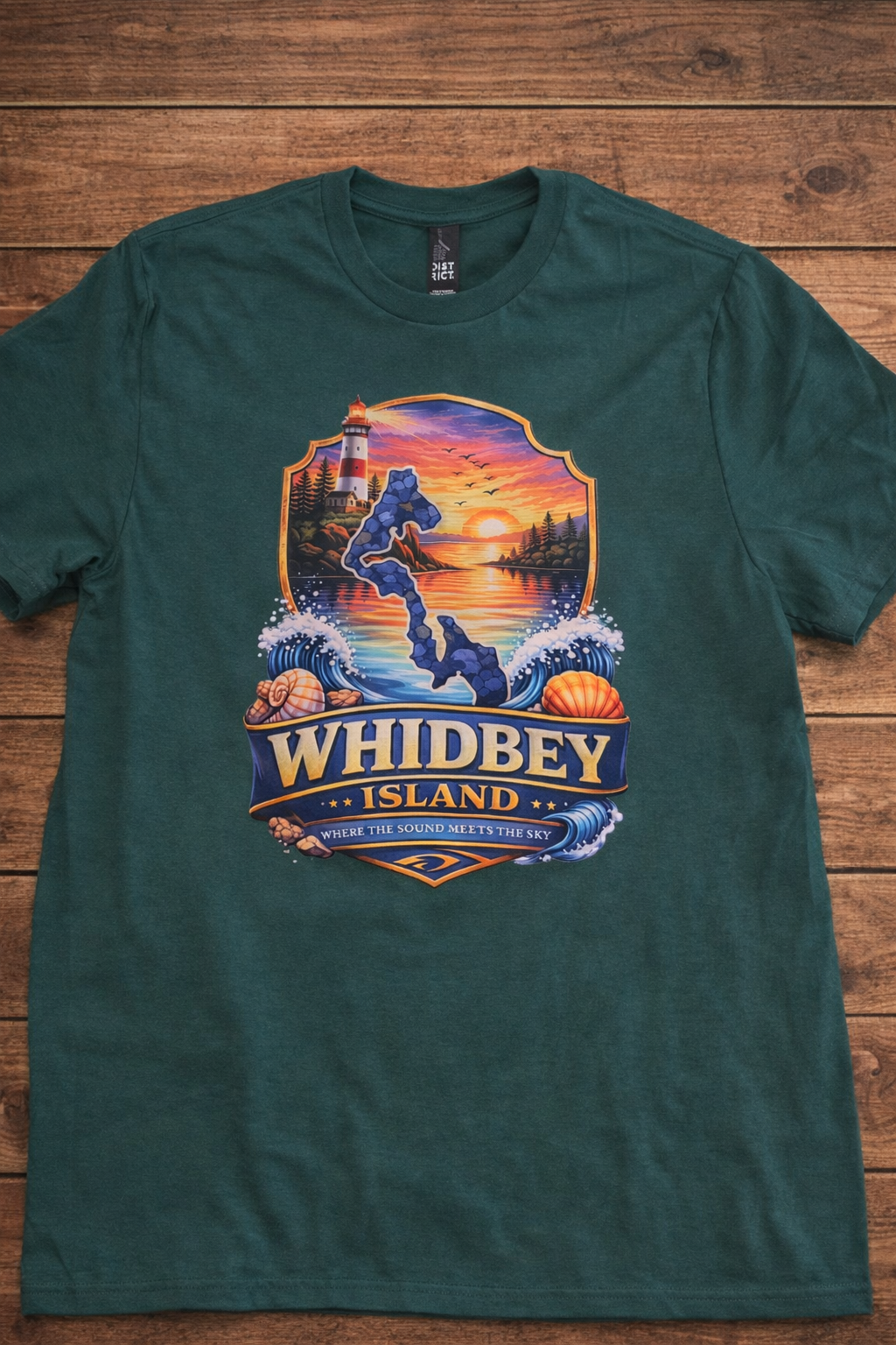 Green Whidbey Island t-shirt with lighthouse, ocean, and sunset design that says Where the Sound Meets the Sky.